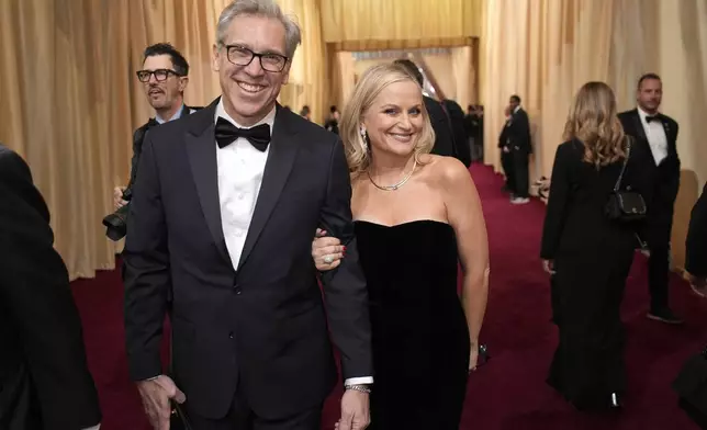 Joel Lovell, left, and Amy Poehler arrive at the Oscars on Sunday, March 2, 2025, at the Dolby Theatre in Los Angeles. (AP Photo/John Locher)