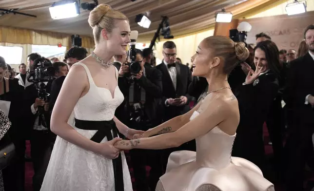 Elle Fanning, left, and Ariana Grande arrive at the Oscars on Sunday, March 2, 2025, at the Dolby Theatre in Los Angeles. (AP Photo/John Locher)