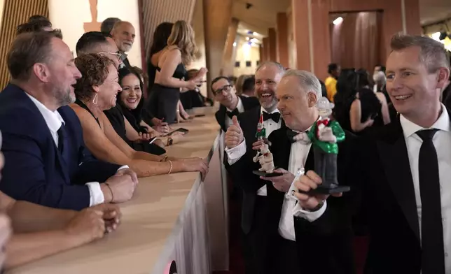 Richard Beek, from left, Nick Park and Merlin Crossingham arrive at the Oscars on Sunday, March 2, 2025, at the Dolby Theatre in Los Angeles. (AP Photo/John Locher)