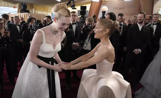 Elle Fanning, left, and Ariana Grande arrive at the Oscars on Sunday, March 2, 2025, at the Dolby Theatre in Los Angeles. (AP Photo/John Locher)