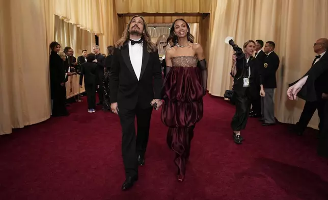Marco Perego-Saldana, left, and Zoe Saldana arrive at the Oscars on Sunday, March 2, 2025, at the Dolby Theatre in Los Angeles. (AP Photo/John Locher)
