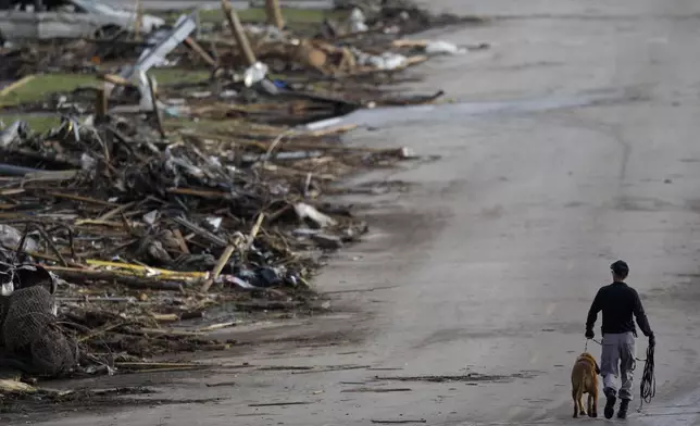 FILE- A rescue worker walks past debris at Joplin High School, which was severely damaged by a tornado in Joplin, Mo., Monday, May 23, 2011. (AP Photo/Charlie Riedel, File)