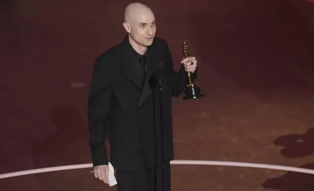 Daniel Blumberg accepts the award for best original score for "The Brutalist" during the Oscars on Sunday, March 2, 2025, at the Dolby Theatre in Los Angeles. (AP Photo/Chris Pizzello)