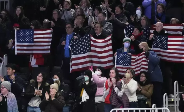 Audience members cheer for Alisa Efimova and Misha Mitrofanov, of the United States, during the pairs free skating program at the figure skating world championships, Thursday, March 27, 2025, in Boston. (AP Photo/Charles Krupa)