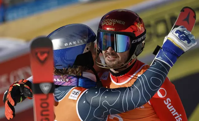 Switzerland's Loic Meillard, right, winner of an alpine ski, men's World Cup slalom, and third-placed Brazil's Lucas Pinheiro Braathen congratulate each other at the finish area, in Hafjell, Norway, Sunday, March 16, 2025. (AP Photo/Gabriele Facciotti)
