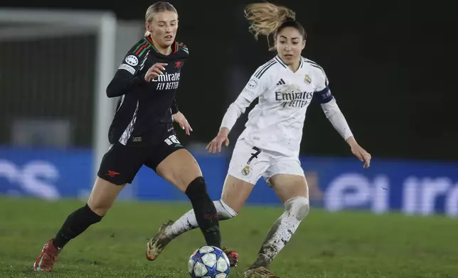 Arsenal's Chloe Kelly, left is chased by Real Madrid's Olga Carmona during the Women's Champions League quarterfinal first leg soccer match between Real Madrid and Arsenal at the Alfredo di Stefano stadium in Madrid, Spain, Tuesday March 18, 2025. (AP Photo/Fran Berg)