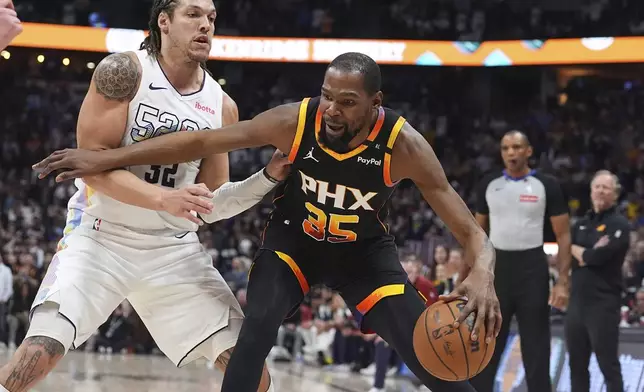 Phoenix Suns forward Kevin Durant (35) drives past Denver Nuggets forward Aaron Gordon in overtime of an NBA basketball game Friday, March 7, 2025, in Denver. (AP Photo/David Zalubowski)