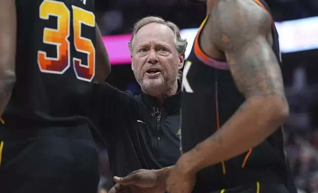 Phoenix Suns head coach Mike Budenholzer directs his team during a timeout in the first half of an NBA basketball game against the Denver Nuggets, Friday, March 7, 2025, in Denver. (AP Photo/David Zalubowski)