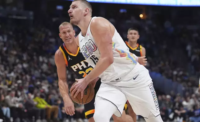Denver Nuggets center Nikola Jokic, front, drives past Phoenix Suns center Mason Plumlee in the first half of an NBA basketball game Friday, March 7, 2025, in Denver. (AP Photo/David Zalubowski)