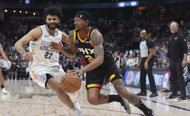 Phoenix Suns guard Bradley Beal, right, drives past Denver Nuggets guard Jamal Murray in overtime of an NBA basketball game Friday, March 7, 2025, in Denver. (AP Photo/David Zalubowski)