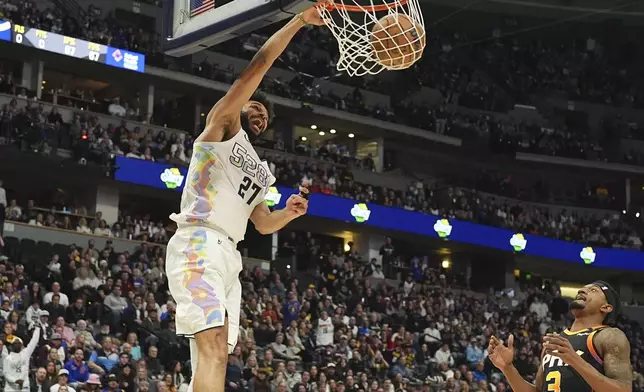 Denver Nuggets guard Jamal Murray, left, dunks as Phoenix Suns guard Bradley Beal, right, covers in the second half of an NBA basketball game Friday, March 7, 2025, in Denver. (AP Photo/David Zalubowski)