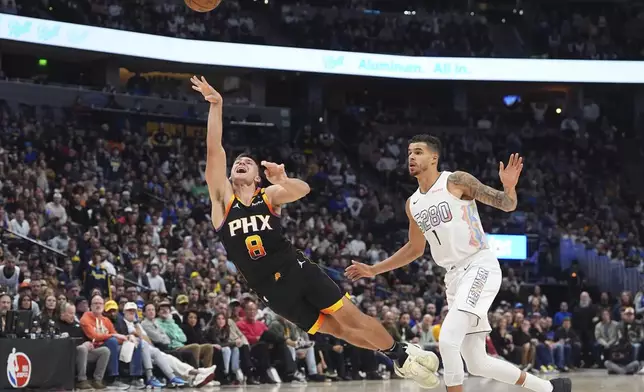 Phoenix Suns guard Grayson Allen, left, flies in the air after being fouled by Denver Nuggets forward Michael Porter Jr. in the second half of an NBA basketball game Friday, March 7, 2025, in Denver. (AP Photo/David Zalubowski)