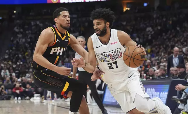 Denver Nuggets guard Jamal Murray, right, drives to the basket past Phoenix Suns guard Devin Booker in the first half of an NBA basketball game Friday, March 7, 2025, in Denver. (AP Photo/David Zalubowski)