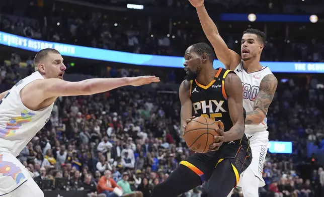 Phoenix Suns forward Kevin Durant, center, passes the ball as Denver Nuggets center Nikola Jokic, left, and forward Michael Porter Jr. defend in overtime of an NBA basketball game Friday, March 7, 2025, in Denver. (AP Photo/David Zalubowski)