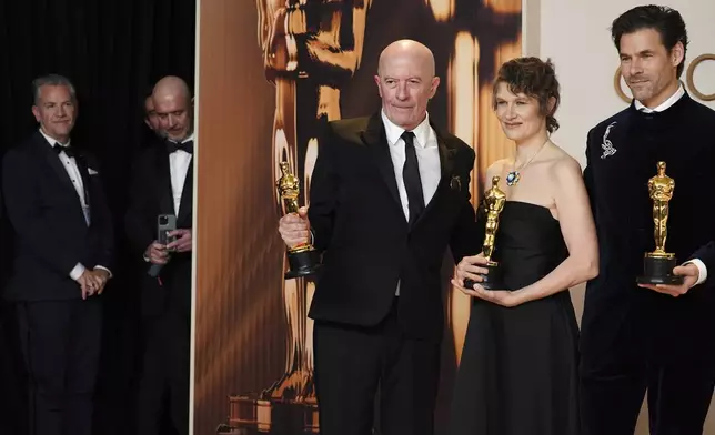 Jacques Audiard, from left, Camille, and Clement Ducol, winners of the award for best original song for "El Mal" from" Emilia Perez," pose in the press room at the Oscars on Sunday, March 2, 2025, at the Dolby Theatre in Los Angeles. (Photo by Jordan Strauss/Invision/AP)