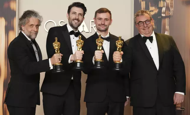 Paul Lambert, from left, Stephen James, Rhys Salcombe, and Gerd Nefzer, winners of the award for best visual effects for "Dune: Part Two," pose in the press room at the Oscars on Sunday, March 2, 2025, at the Dolby Theatre in Los Angeles. (Photo by Jordan Strauss/Invision/AP)
