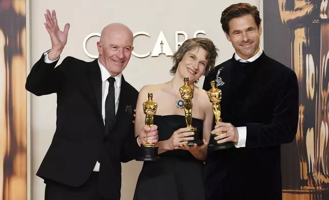 Jacques Audiard, from left, Camille, and Clement Ducol, winners of the award for best original song for "El Mal" from" Emilia Perez," pose in the press room at the Oscars on Sunday, March 2, 2025, at the Dolby Theatre in Los Angeles. (Photo by Jordan Strauss/Invision/AP)