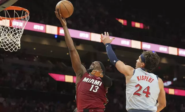 Miami Heat center Bam Adebayo (13) drives to the basket over Washington Wizards forward Corey Kispert (24) during the second half of an NBA basketball game, Monday, March 3, 2025, in Miami. (AP Photo/Marta Lavandier)