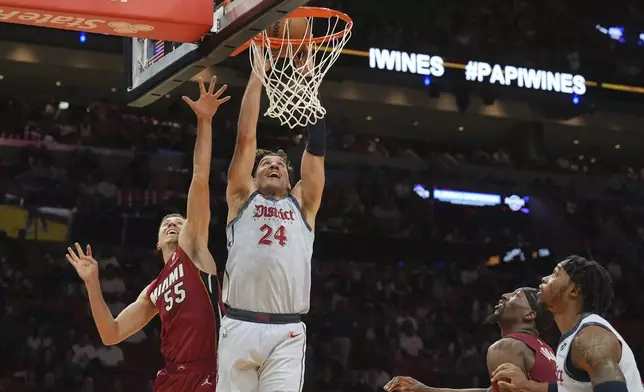 Washington Wizards forward Corey Kispert (24) dunks the ball over Miami Heat forward Duncan Robinson (55) during the first half of an NBA basketball game, Monday, March 3, 2025, in Miami. (AP Photo/Marta Lavandier)