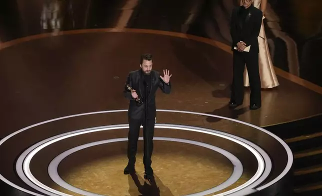 Kieran Culkin accepts the award for best performance by an actor in a supporting role for "A Real Pain" during the Oscars on Sunday, March 2, 2025, at the Dolby Theatre in Los Angeles. Robert Downey Jr. looks on from right. (AP Photo/Chris Pizzello)