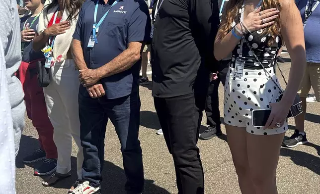 Michael Andretti, third from left, stands with his son, Mario, left, wife Jodi Ann, second from left, and Andretti Global new owner Dan Towriss, second from right, with his wife Cassidy Marie, right, before the Grand Prix of St. Petersburg auto race Sunday, March 2, 2025, in St. Petersburg, Fla. (AP Photo/Jenna Fryer)