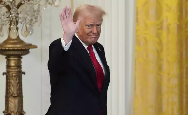 President Donald Trump waves after speaking at a reception celebrating Women's History Month in the East Room of the White House, Wednesday, March 26, 2025, in Washington. (AP Photo/Mark Schiefelbein)