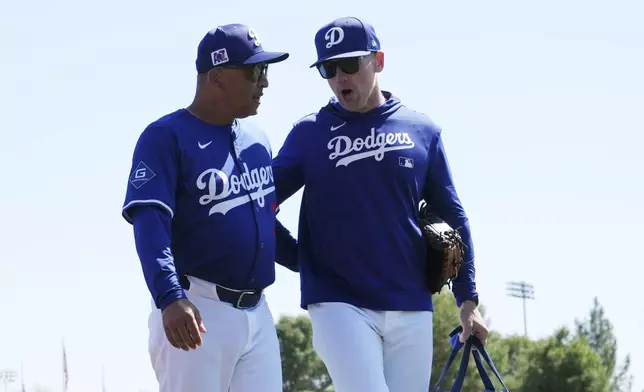 Los Angeles Dodgers manager Dave Roberts, left, talks with Dodgers' Brandon McDaniel, Major League Development Integration Coach, prior to a spring training baseball game against the Athletics, Sunday, March 9, 2025, in Phoenix. (AP Photo/Ross D. Franklin)