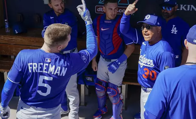 Los Angeles Dodgers first baseman Freddie Freeman (5) and manager Dave Roberts (30) fire each other up before the start of their spring training baseball game against the Colorado Rockies, Thursday, Feb. 27, 2025, in Scottsdale, Ariz. (AP Photo/Darryl Webb)