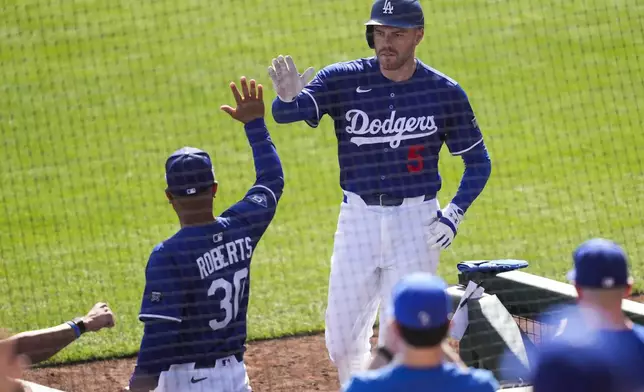 Los Angeles Dodgers designated hitter Freddie Freeman (5) celebrates with manager Dave Roberts after hitting a home run during the sixth inning of a spring training baseball game against the San Francisco Giants, Saturday, March 1, 2025, in Phoenix. (AP Photo/Ashley Landis)