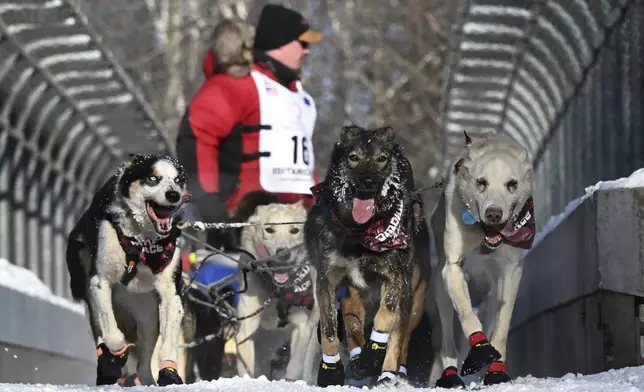 FILE - Matt Hall's team crosses the Northern Lights bridge near Goose Lake during the ceremonial start of the Iditarod Trail Sled Dog Race, Saturday, March 2, 2024. (Anne Raup/Anchorage Daily News via AP)