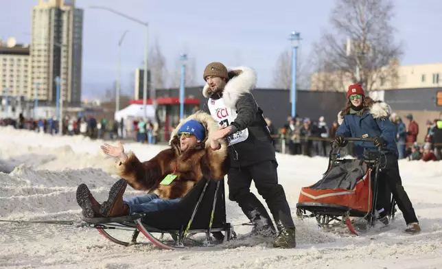 Riley Dyche (17), of Big Lake, Alaska, turns the corner onto Cordova Street during the Ceremonial Start of the Iditarod Trail Sled Dog Race in Anchorage, Alaska., Saturday, March 1, 2025. (AP Photo/Amanda Loman)