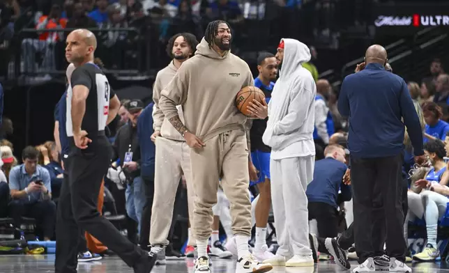 Dallas Mavericks' Anthony Davis, center, in street clothes due to an injury, looks on during the first half of an NBA basketball game against the Detroit Pistons, Friday, March 21, 2025, in Dallas, Texas. (AP Photo/Albert Pena)