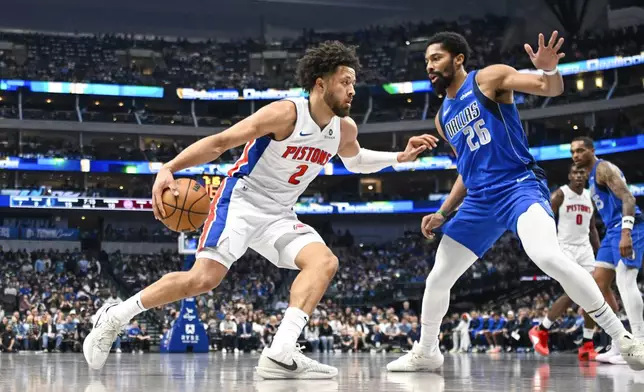 Detroit Pistons guard Cade Cunningham, left, drives against Dallas Mavericks guard Spencer Dinwiddie (26) during the first half of an NBA basketball game, Friday, March 21, 2025, in Dallas, Texas. (AP Photo/Albert Pena)