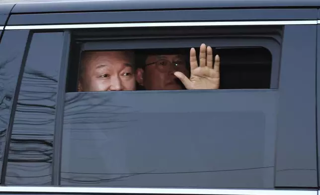 Impeached South Korean President Yoon Suk Yeol waves to his supporters upon his arrival outside of presidential residence in Seoul, South Korea, Saturday, March 8, 2025. (Kim In-chul/Yonhap via AP)
