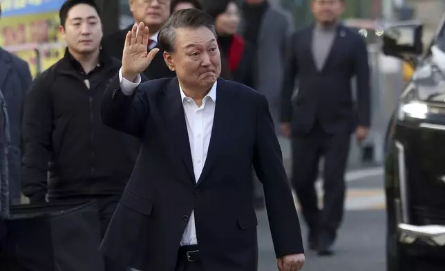 Impeached South Korean President Yoon Suk Yeol waves to his supporters as he comes out of a detention center in Uiwang, South Korea, Saturday, March 8, 2025. (Hong Hyo-shik/Newsis via AP)