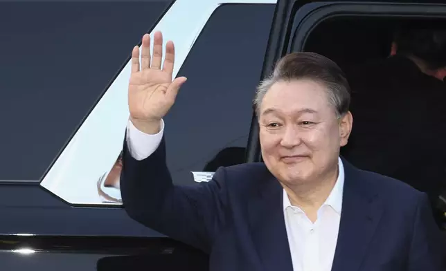 Impeached South Korean President Yoon Suk Yeol greets to his supporters upon his arrival outside of presidential residence in Seoul, South Korea, Saturday, March 8, 2025. (Kim In-chul/Yonhap via AP)