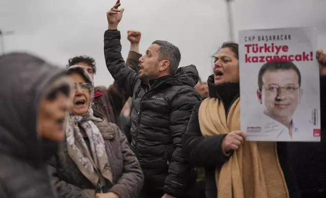 People chant slogans and hold posters of Istanbul Mayor Ekrem Imamoglu as they protest outside the Vatan Security Department, where Imamoglu is expected to be taken following his arrest in Istanbul, Turkey, Wednesday, March 19, 2025. (AP Photo/Francisco Seco)