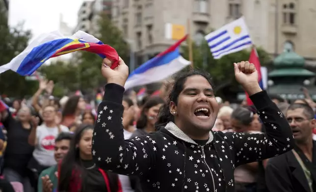 People gather with Uruguay's flags prior to President-elect Yamandu Orsi's swearing-in ceremony, on Inauguration Day in Montevideo, Uruguay, Saturday, March 1, 2025. (AP Photo/Matilde Campodonico)
