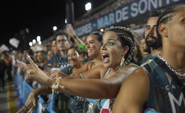 Fans cheer during the Viradouro samba school parade, during Carnival celebrations at the Sambadrome in Rio de Janeiro, Monday, March 3, 2025. (AP Photo/Silvia Izquierdo)