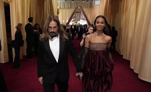 Marco Perego-Saldana, left, and Zoe Saldana arrive at the Oscars on Sunday, March 2, 2025, at the Dolby Theatre in Los Angeles. (AP Photo/John Locher)