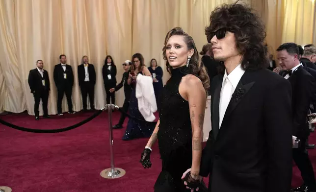 Miley Cyrus, left, and Maxx Morando arrive at the Oscars on Sunday, March 2, 2025, at the Dolby Theatre in Los Angeles. (AP Photo/John Locher)