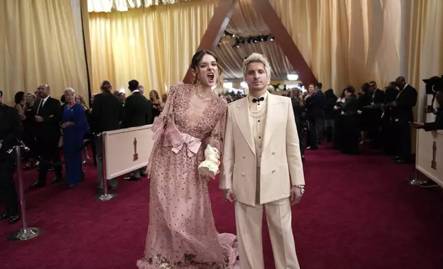 Charlotte Lawrence, left, and Andrew Watt arrive at the Oscars on Sunday, March 2, 2025, at the Dolby Theatre in Los Angeles. (AP Photo/John Locher)