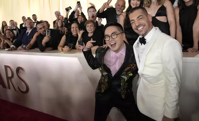 Bowen Yang, left, and Matt Rogers arrive at the Oscars on Sunday, March 2, 2025, at the Dolby Theatre in Los Angeles. (AP Photo/John Locher)