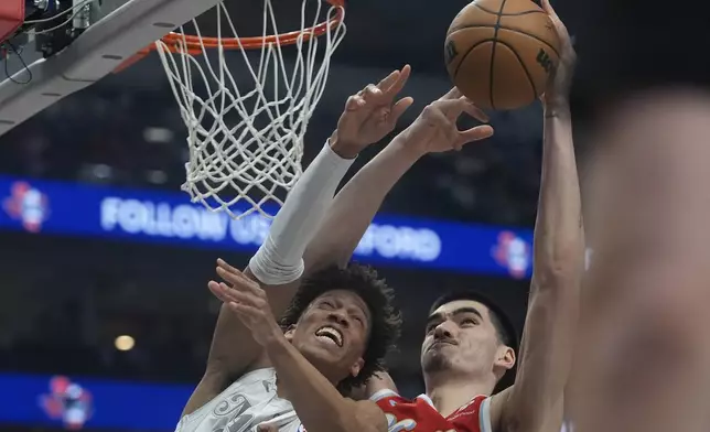 Memphis Grizzlies center Zach Edey, right, and Dallas Mavericks forward Kessler Edwards, left, reach for a rebound during the first half of an NBA basketball game in Dallas, Friday, March 7, 2025. (AP Photo/LM Otero)
