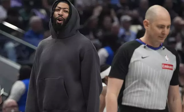Injured Dallas Mavericks forward Anthony Davis, left, questions a call by referee Marat Kogut, right, during a timeout in the first half of an NBA basketball game against the Memphis Grizzlies in Dallas, Friday, March 7, 2025. (AP Photo/LM Otero)