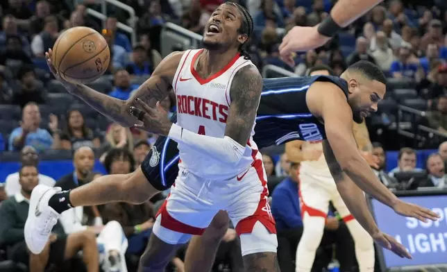 Houston Rockets guard Jalen Green, left, struggles to get off a shot as Orlando Magic guard Cory Joseph runs into him from behind during the second half of an NBA basketball game, Wednesday, March 19, 2025, in Orlando, Fla. (AP Photo/John Raoux)
