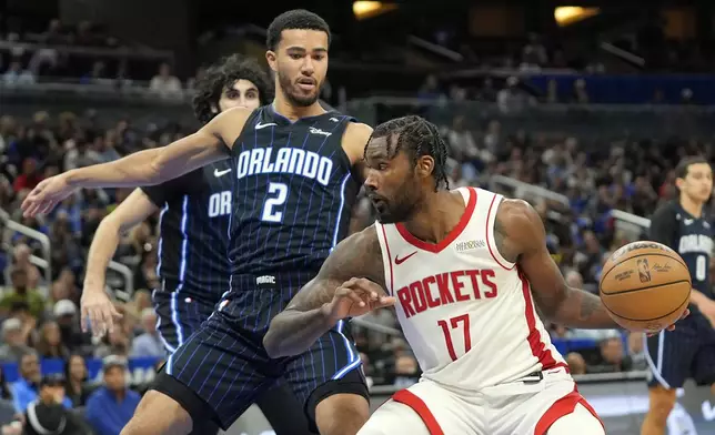 Houston Rockets forward Tari Eason (17) makes a move to the basket against Orlando Magic guard Caleb Houstan (2) during the second half of an NBA basketball game, Wednesday, March 19, 2025, in Orlando, Fla. (AP Photo/John Raoux)