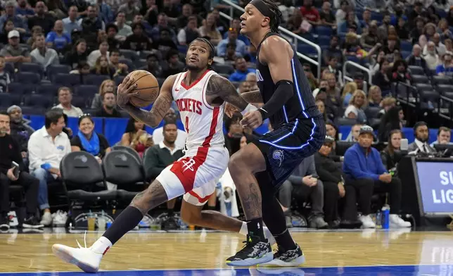 Houston Rockets guard Jalen Green (4) drives past Orlando Magic forward Paolo Banchero, right, during the second half of an NBA basketball game, Wednesday, March 19, 2025, in Orlando, Fla. (AP Photo/John Raoux)