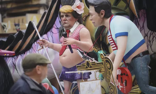 Cardboard sculptures known as "Ninots" depicting U.S. President Donald Trump and Elon Musk, right, are displayed during the Fallas festival in Valencia, Spain, Wednesday, March 19, 2025. Five months after deadly floods ravaged Valencia, the Spanish city will host its biggest celebration of the year: Las Fallas. Sculptures were built using wreckage from peoples' homes and lampoon politicians accused of mishandling the catastrophe. (AP Photo/Alberto Saiz)