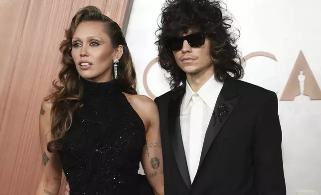 Miley Cyrus, left, and Maxx Morando arrive at the Oscars on Sunday, March 2, 2025, at the Dolby Theatre in Los Angeles. (Photo by Jordan Strauss/Invision/AP)